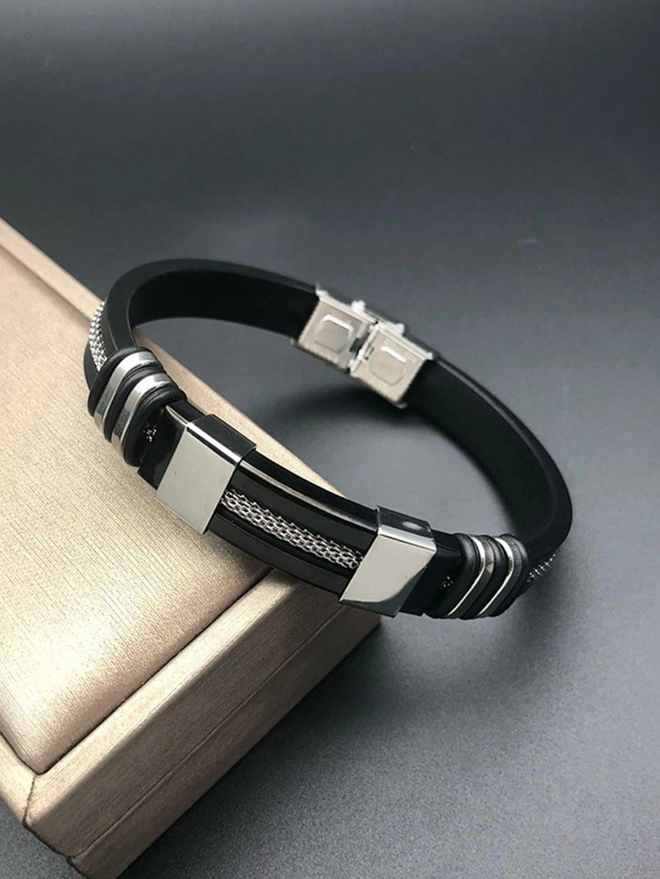 Pulsera negra con cierre reforzado y detalles plateados